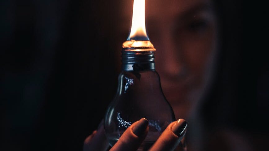 woman holding lighted oil lamp
